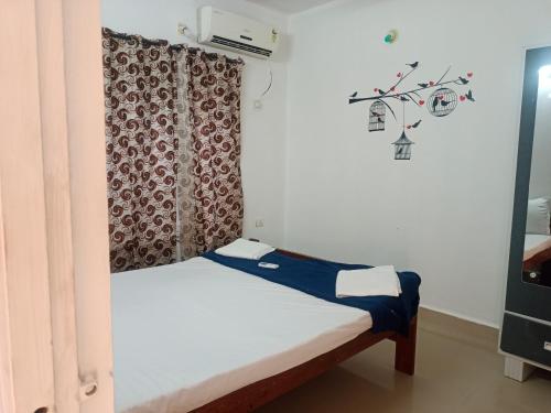 uma pequena cama num quarto com uma janela em RONNE'S Pamela 1BHK Apartment in Anjuna em Assagao