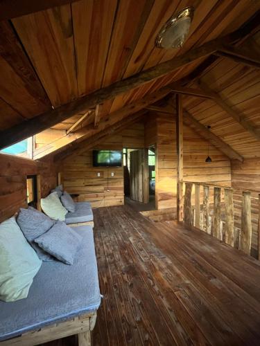 a room with two beds in a wooden cabin at Cabaña Trojas Valverde Vega in Trojas