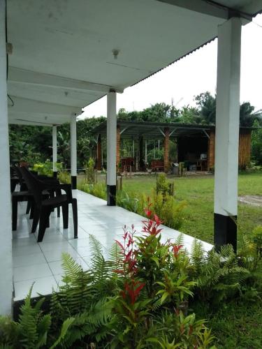 a pavilion with a table and chairs in a garden at Rago's Homestay in Kelimutu
