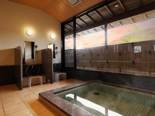 a large bathroom with a tub and a window at Ryotei Jyusouya in Sango