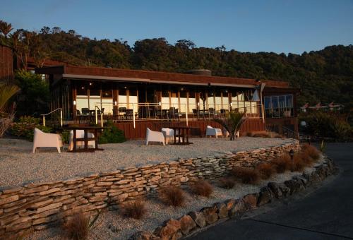 a building with a table and chairs in front of it at Scenic Hotel Punakaiki in Punakaiki