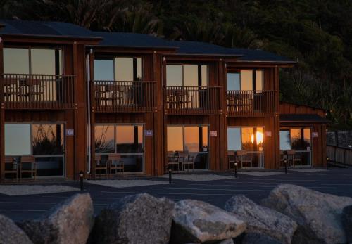 a building with windows and rocks in front of it at Scenic Hotel Punakaiki in Punakaiki