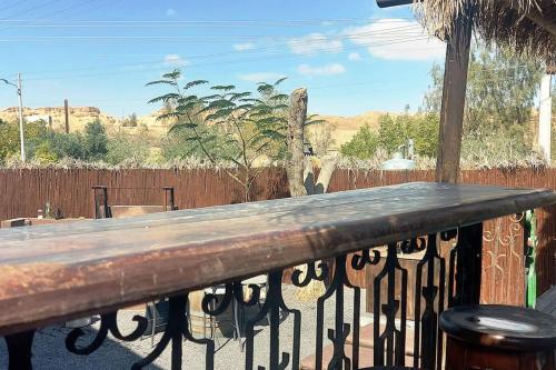 a wooden bench on a balcony with a fence at הבית החום בערבה in Sappir