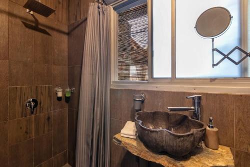 a bathroom with a stone sink and a window at הבית החום בערבה in Sappir