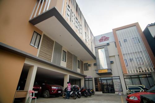 a person standing in front of a building with motorcycles at DLT Suites Cebu powered by Cocotel in Minglanilla