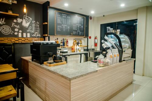 a restaurant with a counter with a coffee shop at DLT Suites Boutique Hotel in Minglanilla