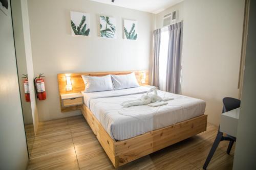 a bedroom with a bed with a stuffed animal on it at DLT Suites Cebu powered by Cocotel in Minglanilla