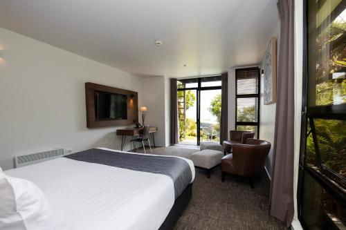 a hotel room with a bed and a television at Scenic Hotel Punakaiki in Punakaiki