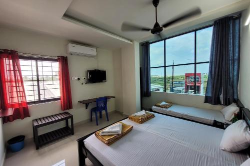 1 dormitorio con 2 camas y ventana grande en Hotel Harigardenia - Airport Mattuthavani ring road, Near Meenakshi Mission Hospital, Madurai, en Tallākulam