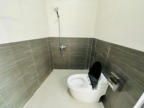 a bathroom with a toilet with a black seat at Ben's House 1 