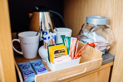 a wooden cabinet with a drawer filled with books and drinks at Palm Court Hotel in Aberdeen