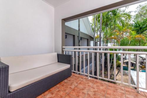 a balcony with a bench and a view of the pool at Paradise On The Beach Resort in Palm Cove