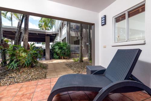 a chair sitting on a patio in front of a building at Paradise On The Beach Resort in Palm Cove