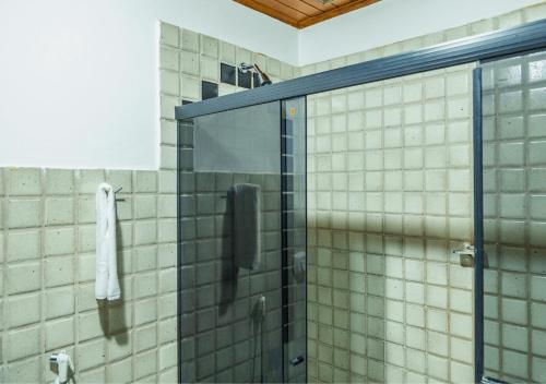 um chuveiro com uma porta de vidro na casa de banho em PSP Resort All Inclusive em Porto Seguro