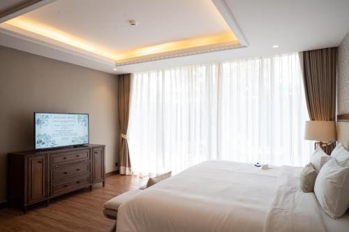 a hotel room with a bed and a television at Hotel Labaris Khao Yai in Mu Si