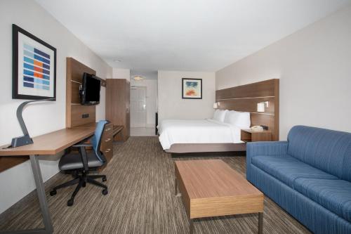 a hotel room with a bed and a desk and a couch at Holiday Inn Express & Suites Tucson, an IHG Hotel in Tucson