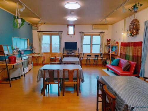 a living room with tables and chairs and a couch at Second House Plus 1組貸し切りのペンション A one group booking per day lodging house in Nikko