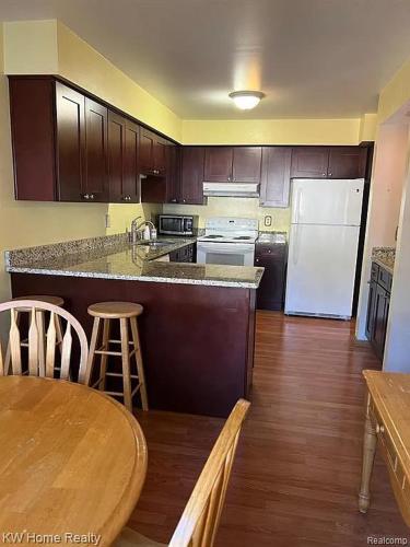 a kitchen with a table and a white refrigerator at Budget 3 bedrooms homestay in Northville