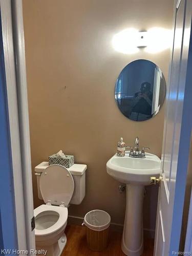 a bathroom with a toilet and a sink and a mirror at Budget 3 bedrooms homestay in Northville