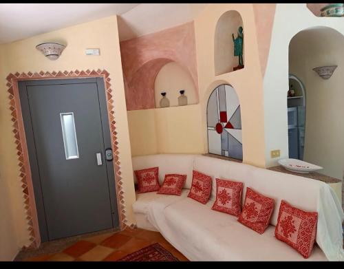 a living room with a white couch and red pillows at villa PICOZZI cannigione in Cannigione