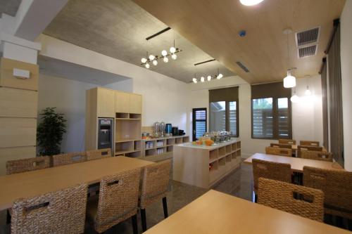 a kitchen and dining room with tables and chairs at Silia Hostel in Jian