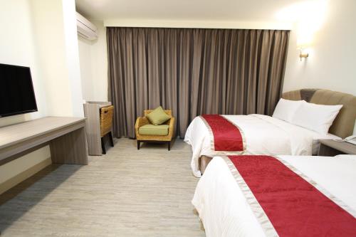 a hotel room with two beds and a television at Silia Hostel in Jian