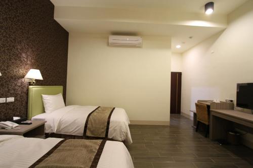 a hotel room with two beds and a television at Silia Hostel in Jian