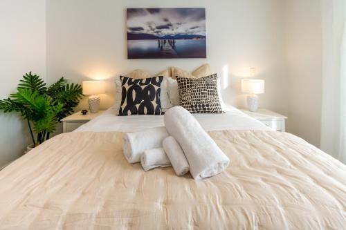 a bedroom with a large white bed with two lamps at Indulge in Christchurch Hagley Park 2 bed 2 bath in Christchurch