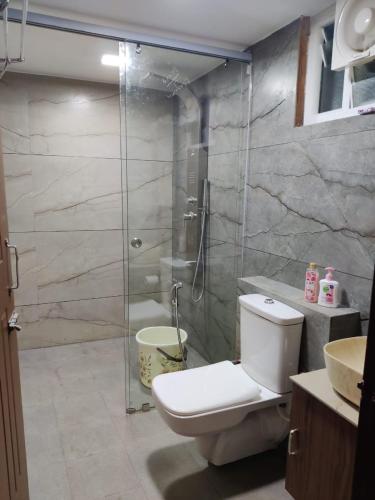 a bathroom with a toilet and a glass shower at Cosmic Connect Trails Kabini in Antarasante