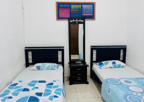2 Betten nebeneinander in einem Zimmer in der Unterkunft Hospedaje DJ in Buga