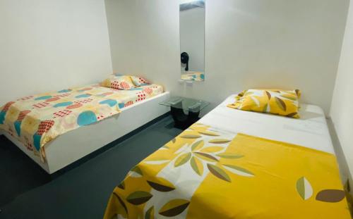 a bedroom with two beds and a mirror at Hospedaje DJ in Buga