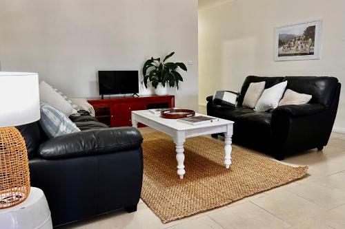 a living room with a couch and a coffee table at Stays on Main in Narrabri