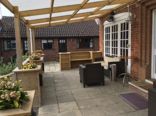 a patio with a wooden pergola at The Swan Motel, Gillingham in Beccles