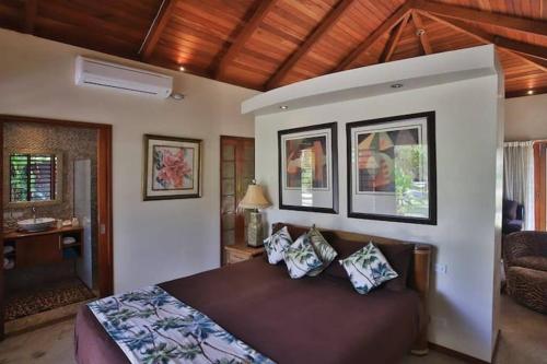 a bedroom with a bed with pillows on it at The Jewel of The Coral Coast in Tangangge