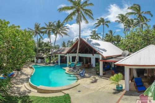 a resort with a swimming pool and palm trees at The Jewel of The Coral Coast in Tangangge