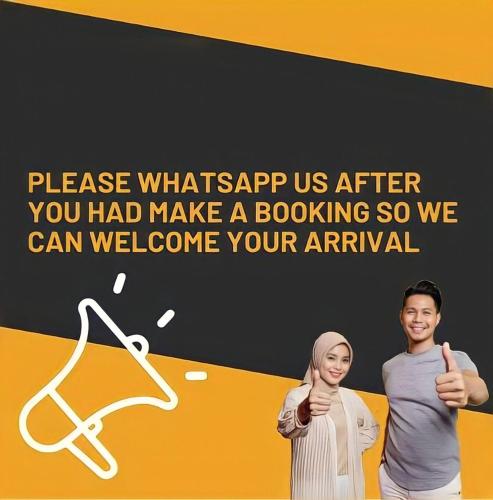 a man and woman giving thumbs up in front of a sign at Sweet Tree Homestay Petaling Jaya in Petaling Jaya