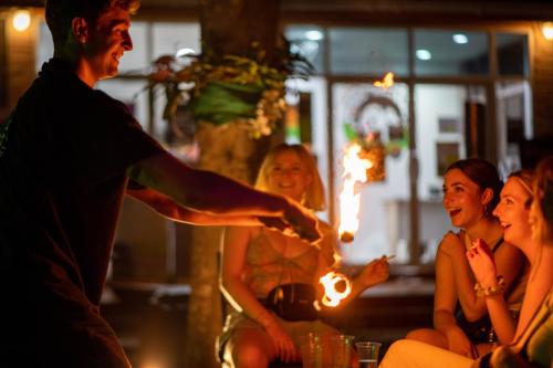 a man is lighting a fire in a group of people at Mad Monkey Pai in Pai