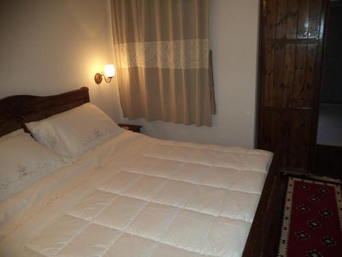 a bedroom with a white bed and a window at Hotel Vila Aleksander in Berat