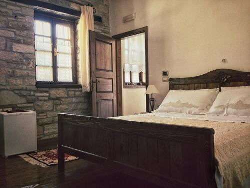 a bedroom with a large bed and a window at Hotel Vila Aleksander in Berat