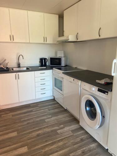 a kitchen with a washing machine and a sink at Holens B&B in Övre Boda