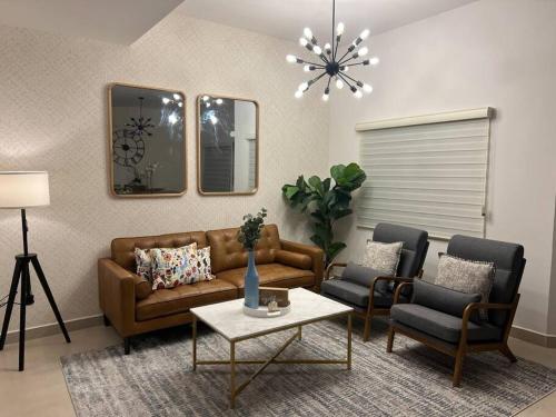 a living room with a couch and two chairs at Consulado Residence in Ciudad Juárez