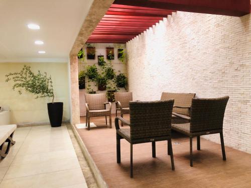 a dining room with chairs and a brick wall at Tambaú Home Beira Mar - com varanda in João Pessoa