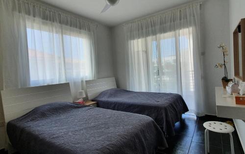 a hotel room with two beds and a window at Mythical Sands AM10 in Paralimni