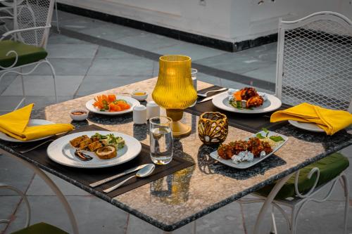 Una mesa con platos de comida encima. en Tree of Life Vantara Resort & Spa, en Udaipur