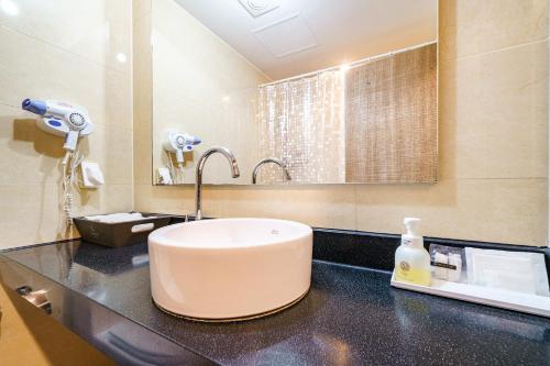a bathroom with a sink and a mirror at Lamer Hotel in Busan