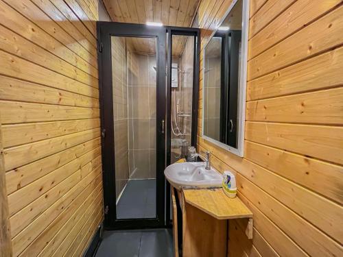 a bathroom with a sink in a wooden wall at Moly Resort in Kampot