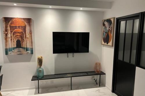 een woonkamer met een flatscreen-tv aan de muur bij Duplex apartment in a residence with swimming pool near Cannes in Le Cannet