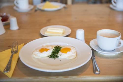 Hotel Agnesen-Hof في Barweiler: طبق من البيض وكوب من القهوة على طاولة