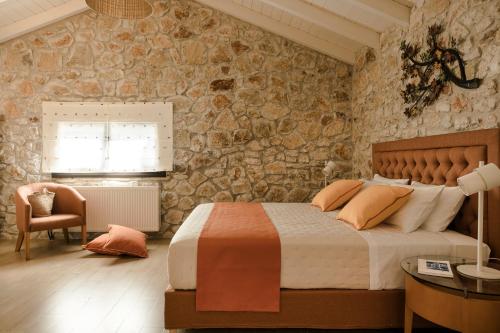 a bedroom with a bed and a stone wall at Τheano Villa in Sami