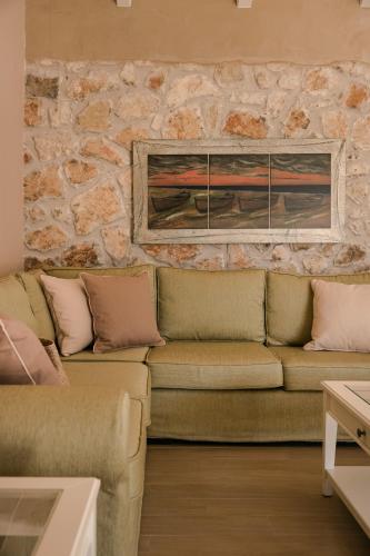 a living room with a couch and a stone wall at Τheano Villa in Sami
